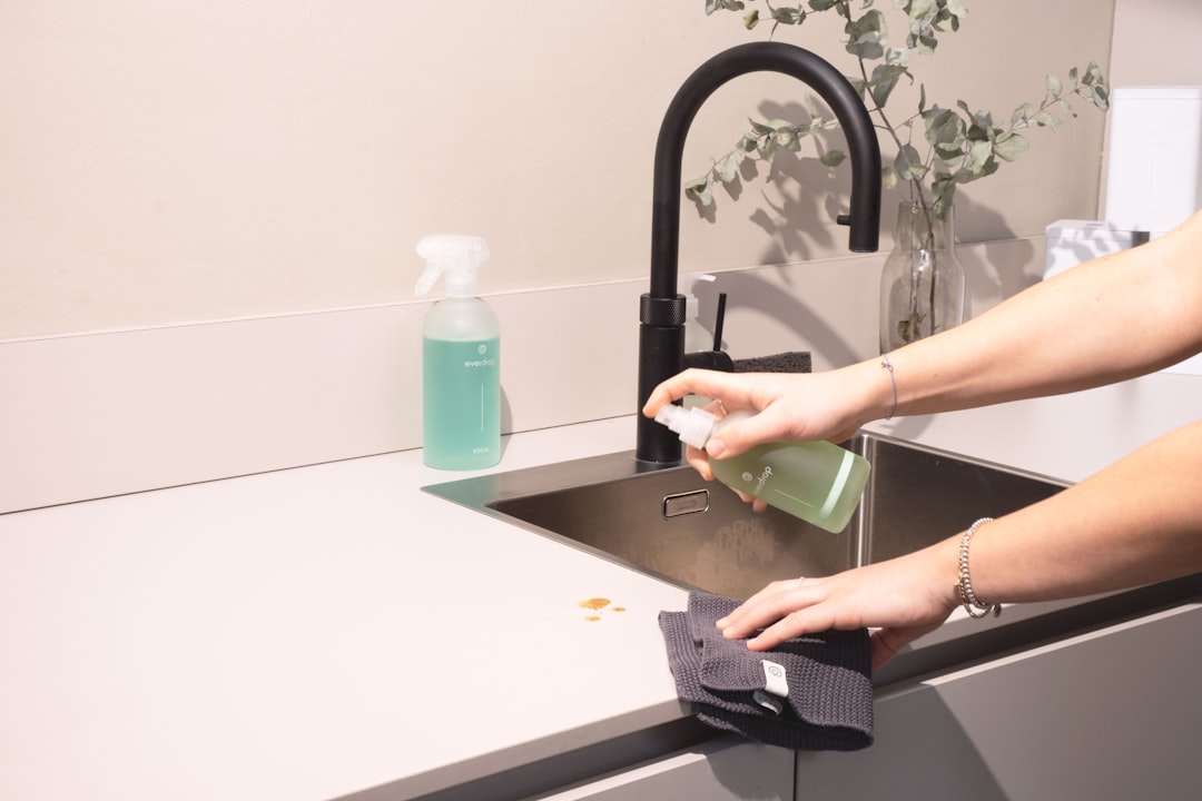 gallery-05 a-woman-is-cleaning-a-kitchen-sink-with-a-rag-sqomdoqb3ws